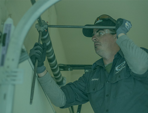 Tech winding a garage door torsion spring